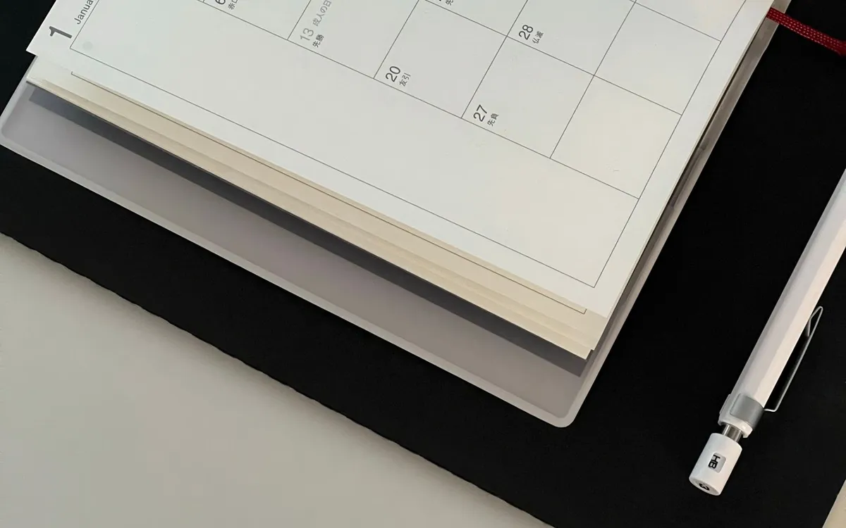 Agenda aberta sobre a mesa com a página de calendário em branco.