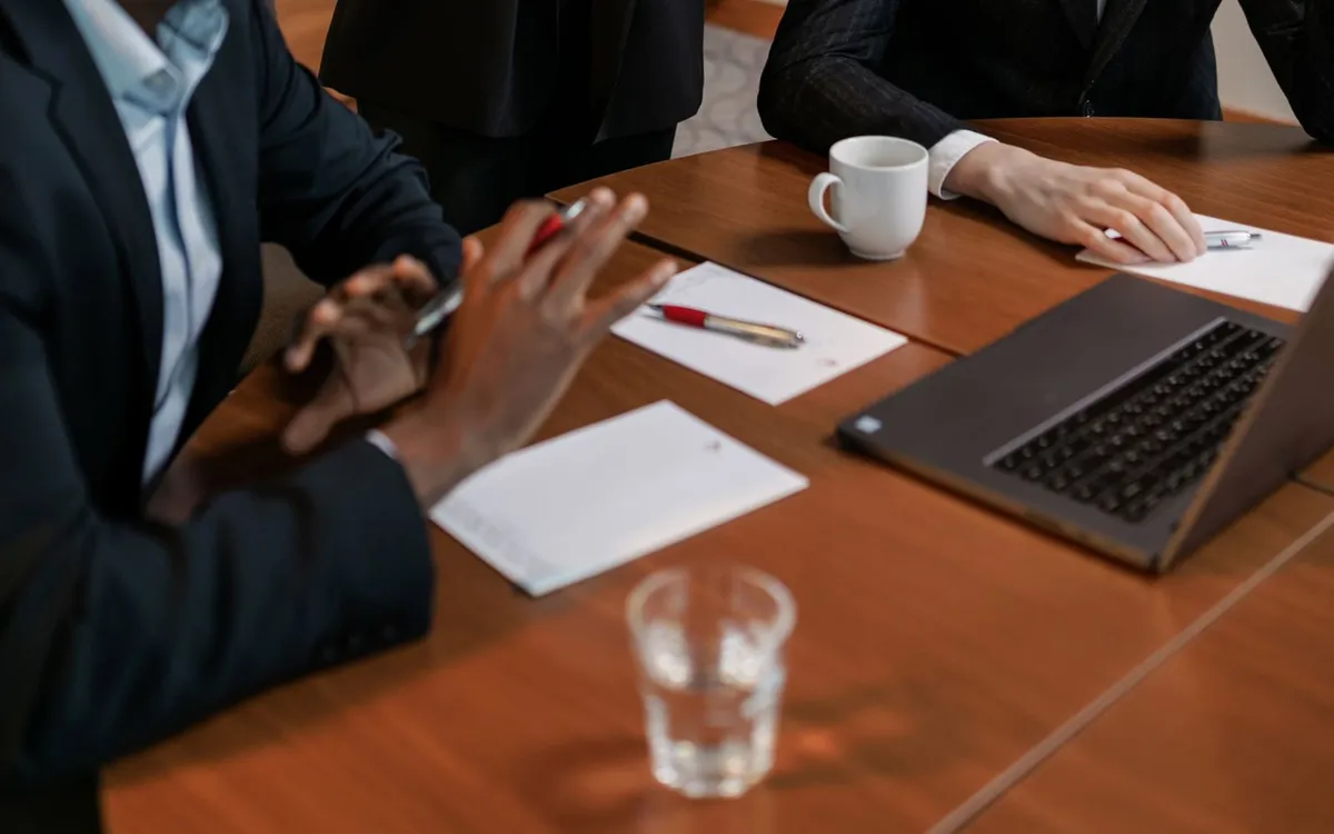 Reunião de negócios com um homem de terno preocupado, apoiando a cabeça na mão.