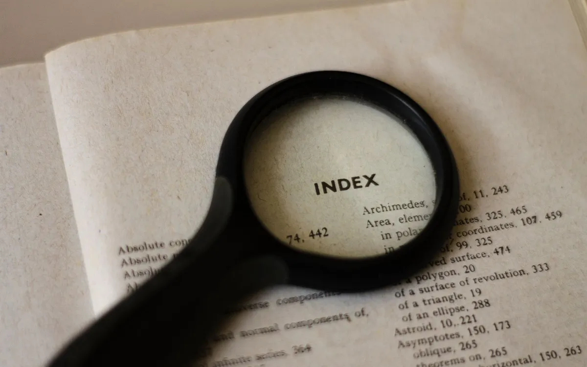Lupa sobre a página de um livro, destacando a palavra index.