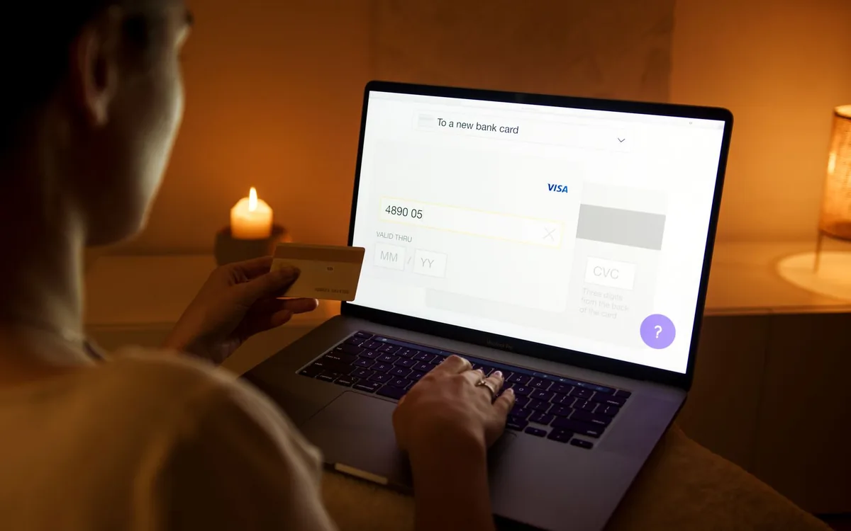 Mulher à noite usando um notebook com uma tela de pagamento aberta.