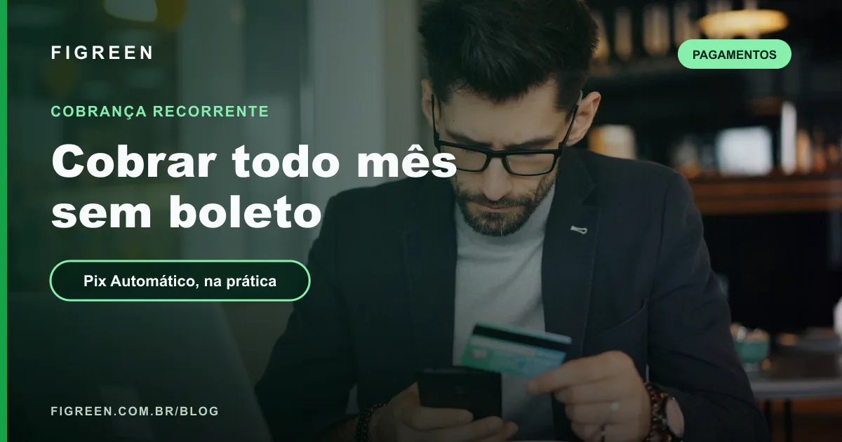Empresário de óculos segurando o celular e um cartão de crédito diante do notebook.