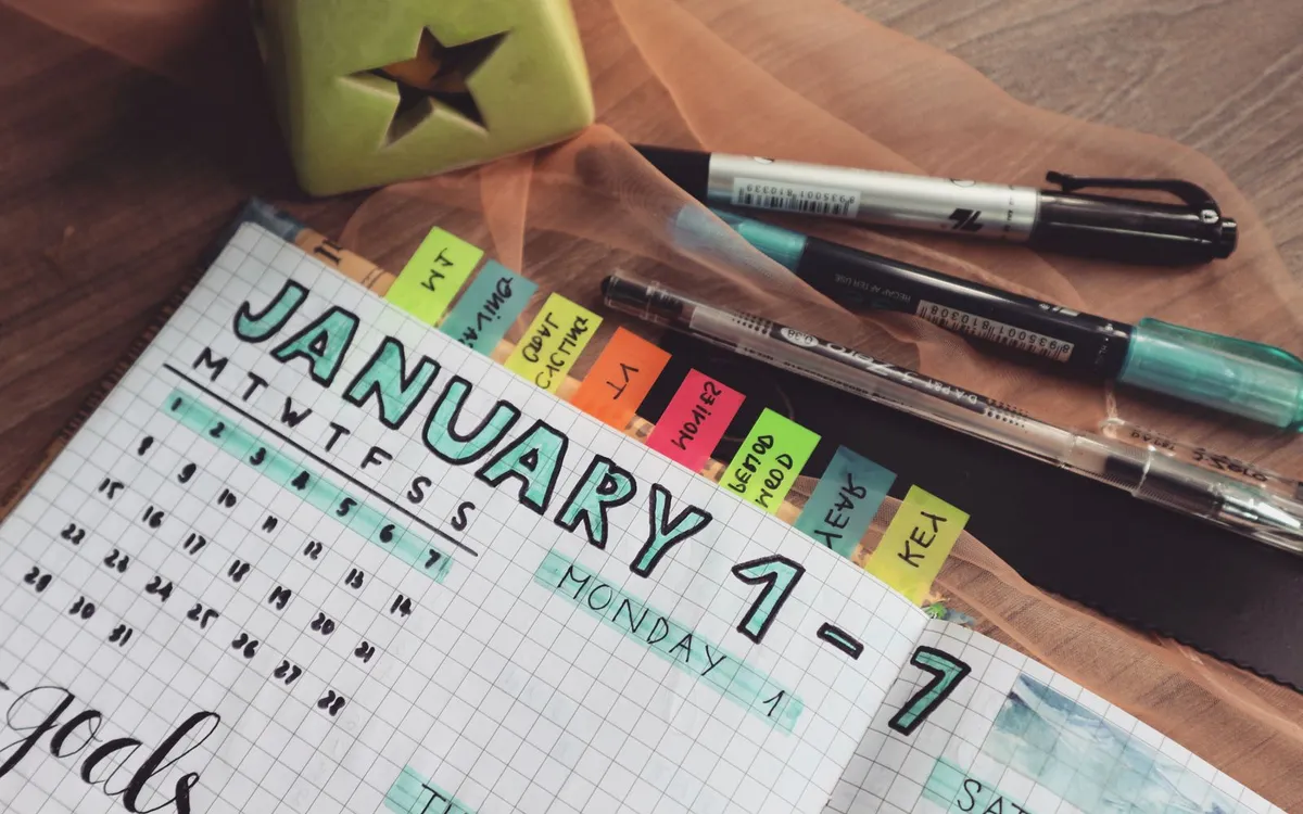 Planner semanal de janeiro com marcadores coloridos e canetas.